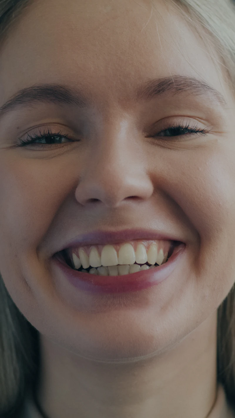 A young woman laughing with bright, white teeth